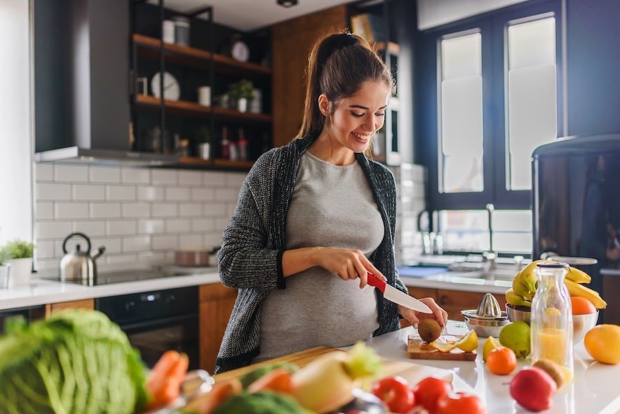 pregnant woman preparing a meal