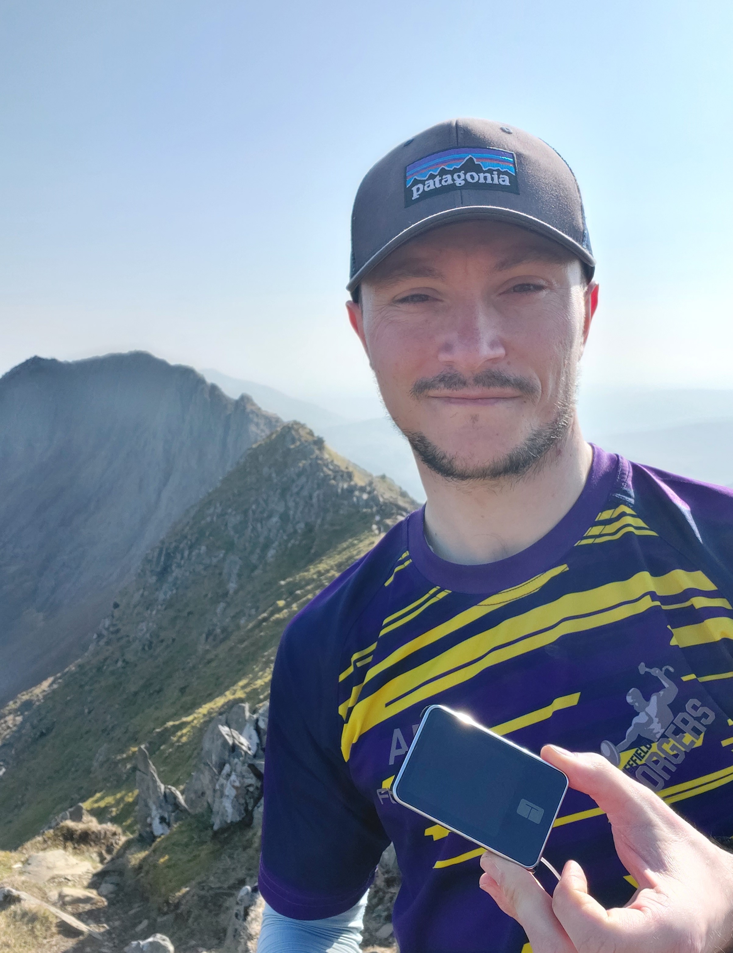 Andrew holding his t:slim on top of a mountain