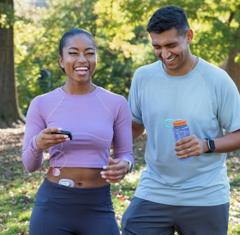Two people in the park, one with a Dexcom G6 and Tandem t:slim