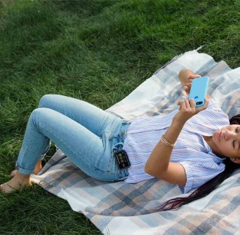 Vrouw die in het gras ligt en haar telefoon gebruikt om een bolus toe te dienen