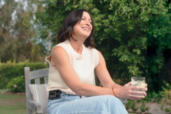 woman in a garden sit enjoying a drink