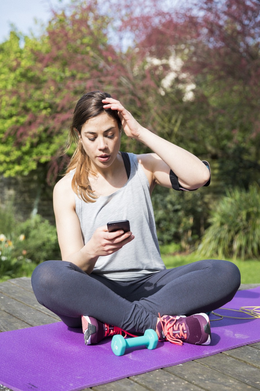 Jonge diabetische vrouw bekijkt haar bloedglucosemetingen na een sportsessie.
