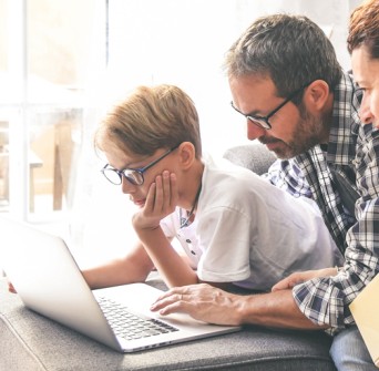 Family around a laptop reading