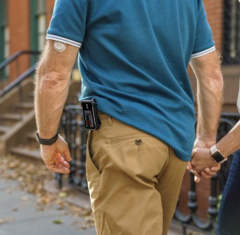 Man walking in street wearing the t:slim X2 and Dexcom G7