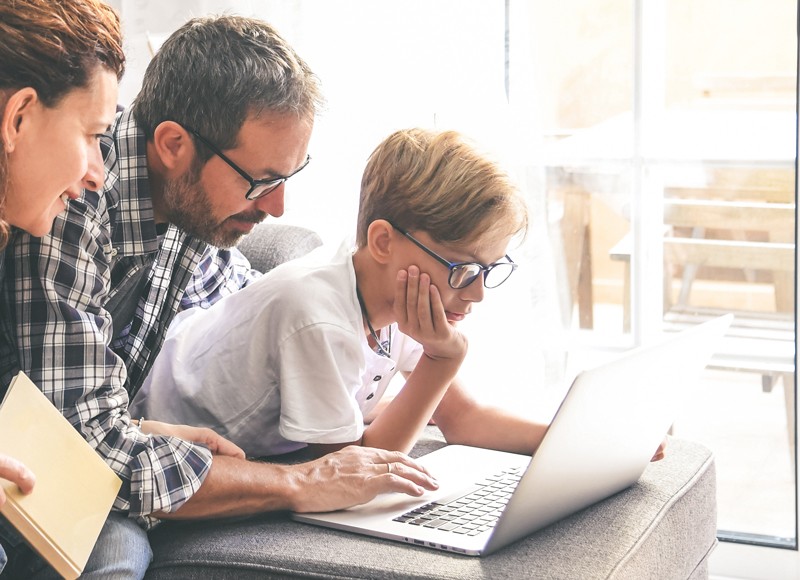 Family around a laptop reading