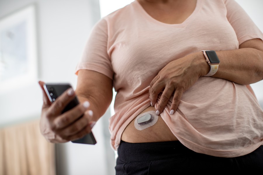 Woman checks her continuous glucose monitor