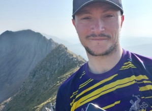 Andrew holding his t:slim on top of a mountain