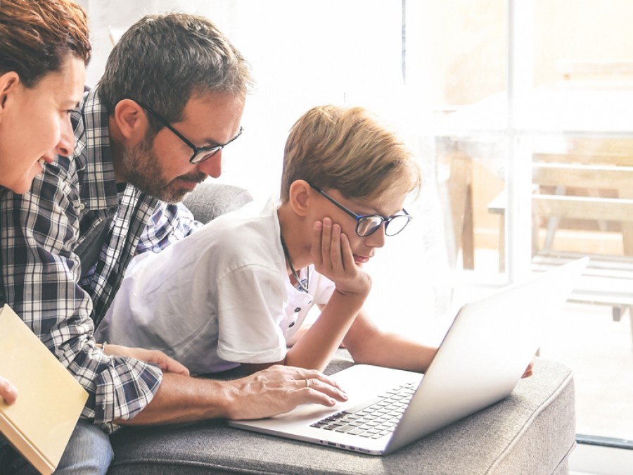 Family around a laptop reading