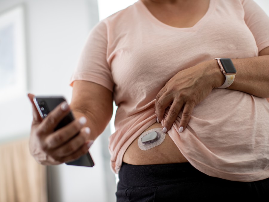 Woman checks her continuous glucose monitor